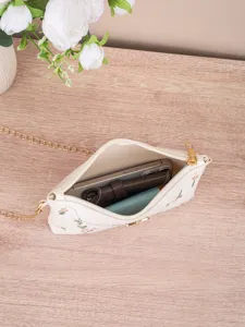 Detailed view of embroidered hobo shoulder bag showing interior capacity, floral design, and chain.