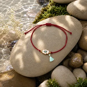 Pulsera de cuerda roja tejida ajustable con dije de mano hamsa de ojo y borla fina.