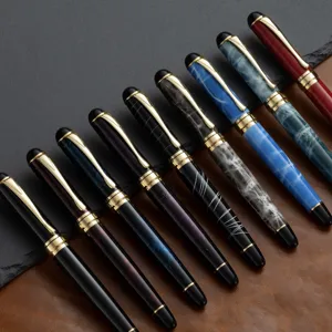 Gros plan détaillé de stylos plume en métal de luxe avec clips dorés et corps marbrés.