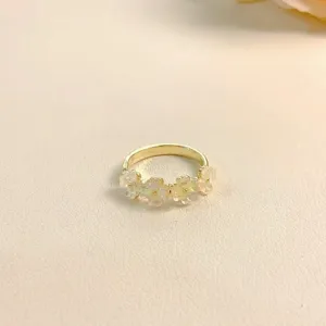 Close-up detail of the elegant floral gold ring featuring translucent blossom motifs.