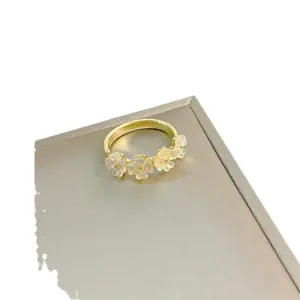 Gold-plated ring featuring dainty translucent flower charms, elegant and chic finger jewelry for women.