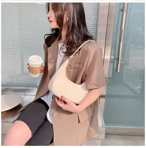 Chic white crescent shoulder bag with minimalist curved design for daily stylish commuter wear.