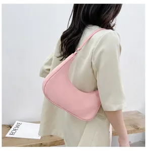 Pink half-moon shoulder bag detail shot, featuring minimalist curved design and smooth texture.