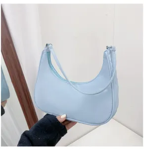 Light blue half moon shoulder bag detail, stylish PU leather underarm handbag for women.