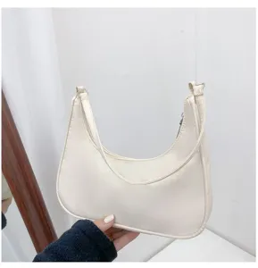 Detail shot of a stylish beige crescent shoulder bag showcasing fine texture and neat stitching.