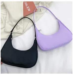 Detail view of stylish half moon underarm shoulder bags in black and purple, chic and sleek.