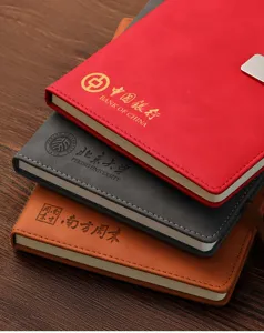 Gros plan détaillé de carnets d'affaires en cuir empilés avec des logos d'entreprise.