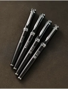 Vue détaillée de quatre stylos de signature en métal noir avec marquage personnalisé.