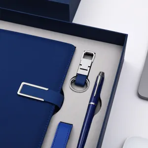Luxe zakelijke geschenkset met blauw lederen notitieboekje, metalen sleutelhanger en elegante pen.