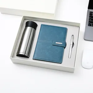 Détail du coffret cadeau d'affaires avec thermos en acier inoxydable, carnet bleu et stylo.
