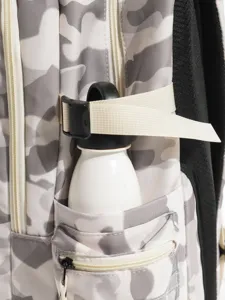 Détail de poche latérale de sac à dos camouflage gris avec porte-bouteille et sangle.
