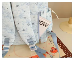 Close-up detail of light blue star print backpack zipper pocket and adjustable strap.