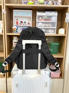 Cute polka dot backpack for women, stylish school bag with luggage strap for travel and daily use.