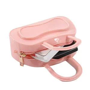 Detail view of a trendy pink PVC jelly cosmetic bag with top handles, zipper closure, compact style.