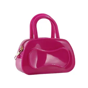 Detail view of hot pink PVC jelly handbag, glossy finish, double top handles and side zipper.