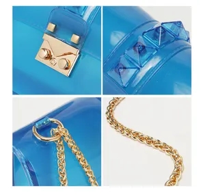Blue transparent PVC crossbody bag with gold chain strap and stylish pyramid stud details.