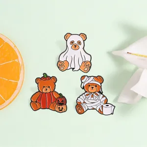 Nahaufnahme niedlicher Halloween Teddybär Emaille Anstecknadeln mit Geist und Kürbis.