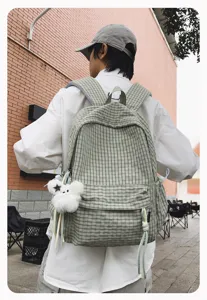 Vista detallada de la mochila a cuadros fresca, que muestra gran capacidad y un colgante.