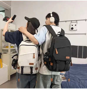 Vista detallada de mochilas elegantes para parejas en blanco y negro con bonito colgante.