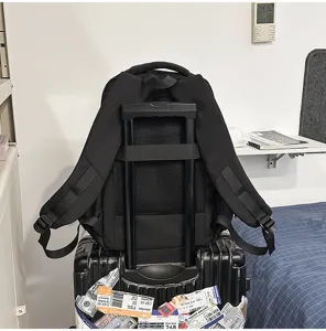 Vista detallada de la mochila de viaje negra con correa para maleta en la habitación.