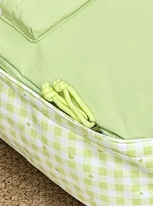 Hellgrüner Schulrucksack Detail mit praktischem Zwei-Wege-Reißverschluss und Karomuster.
