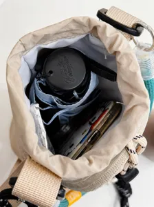 Borsa a tracolla per telefono in tela beige, dettaglio capacità interna per oggetti quotidiani