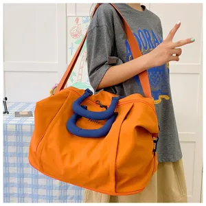 Large capacity travel duffel bag with waterproof fabric and stylish blue handles for gym.
