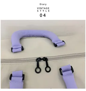 Close-up detail of travel bag featuring purple padded handles and black ring zipper pull.