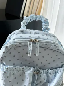 Hellblaue Pünktchen Rucksack mit Rüschengriff und praktischem Doppelreißverschluss für Alltag.