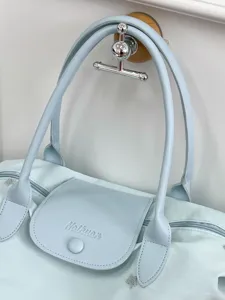 Light blue large capacity travel tote bag with shoulder straps, stylish commuter handbag.