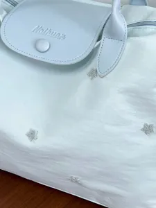 Lightweight large capacity travel tote bag, casual shoulder bag with star embroidery details.