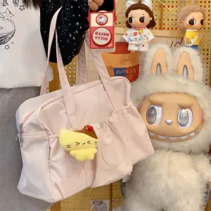 Casual pink canvas tote bag with cute yellow plush pendant for daily commute and travel