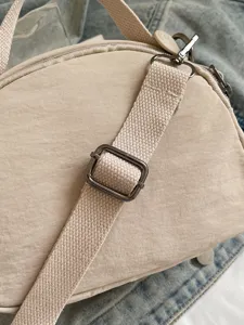 Solid color nylon crossbody bag with adjustable strap and durable metal hardware for women.