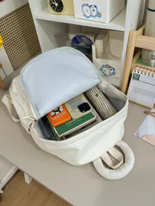 Sac a dos en toile blanche avec grande capacite, ideal pour les deplacements quotidiens et voyages.