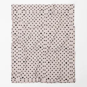 Close-up view of soft polka dot scarf detail, featuring lightweight pink shawl fabric texture.