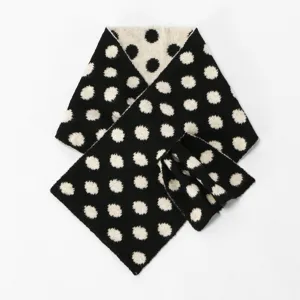 Detalle de bufanda de punto de lunares negros y blancos, textura suave y estilo de invierno.