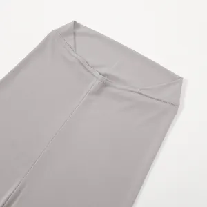 Close-up detail of grey women's leggings elastic waistband, neat stitching and soft fabric.