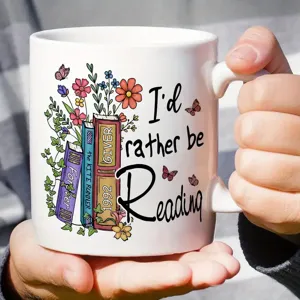 Gros plan d'une tasse en céramique blanche avec impression artistique de livres et fleurs.