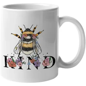 White ceramic coffee mug featuring a cute bumblebee and floral illustration design.