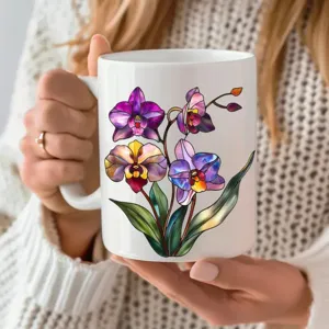 White ceramic coffee mug with colorful stained glass orchid design held in hands, closeup view