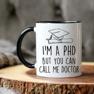 Primer plano detallado de una taza de cerámica con diseño de graduación y frase divertida.