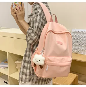 Casual pink backpack detail showing spacious compartment, front pocket and cute cloud charm design.