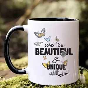 Nahaufnahme Detail der Keramiktasse mit Schmetterlingsmotiven und inspirierendem Textdruck.