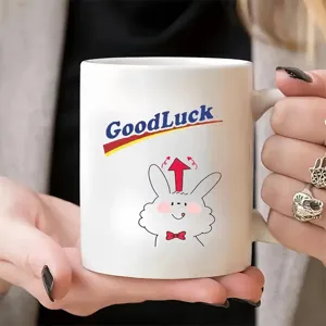 Tasse à café en céramique blanche avec motif de lapin mignon et texte GoodLuck pour bureau.