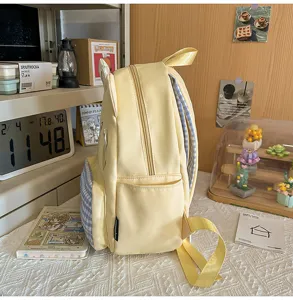 Cute yellow student backpack with blue plaid trim and cartoon ear design for school use.