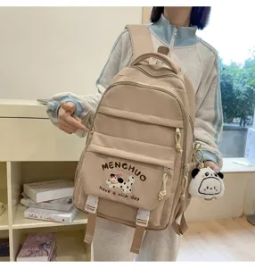 Detailansicht des khakifarbenen Schulrucksacks mit niedlicher Hunderstickerei und Fächern.