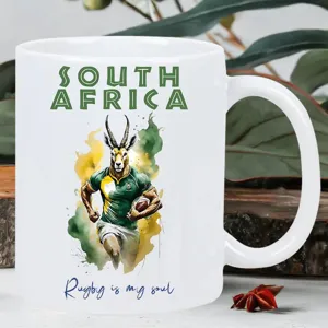 Tazza da caffè in ceramica bianca con illustrazione tema rugby Sudafrica e testo.