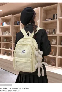 Sweet quilted school backpack for girls with smiley badge and rabbit decor detail.