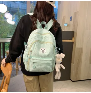 Mint green student backpack with cute smile badge and rabbit pendant, sweet casual school bag.