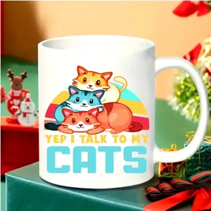 Close-up detail shot of the white ceramic coffee mug featuring cute cat illustration graphic.
